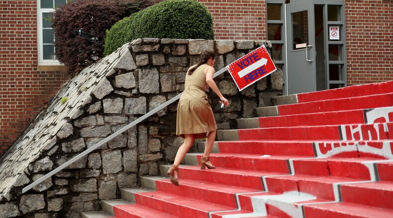 Allison Plummer walks up the steps toward the gym before she votes during the Georgia runoff election voting at Henry W. Grady High School on Tuesday, July 24, 2018, in Atlanta.  (JASON GETZ/SPECIAL TO THE AJC)