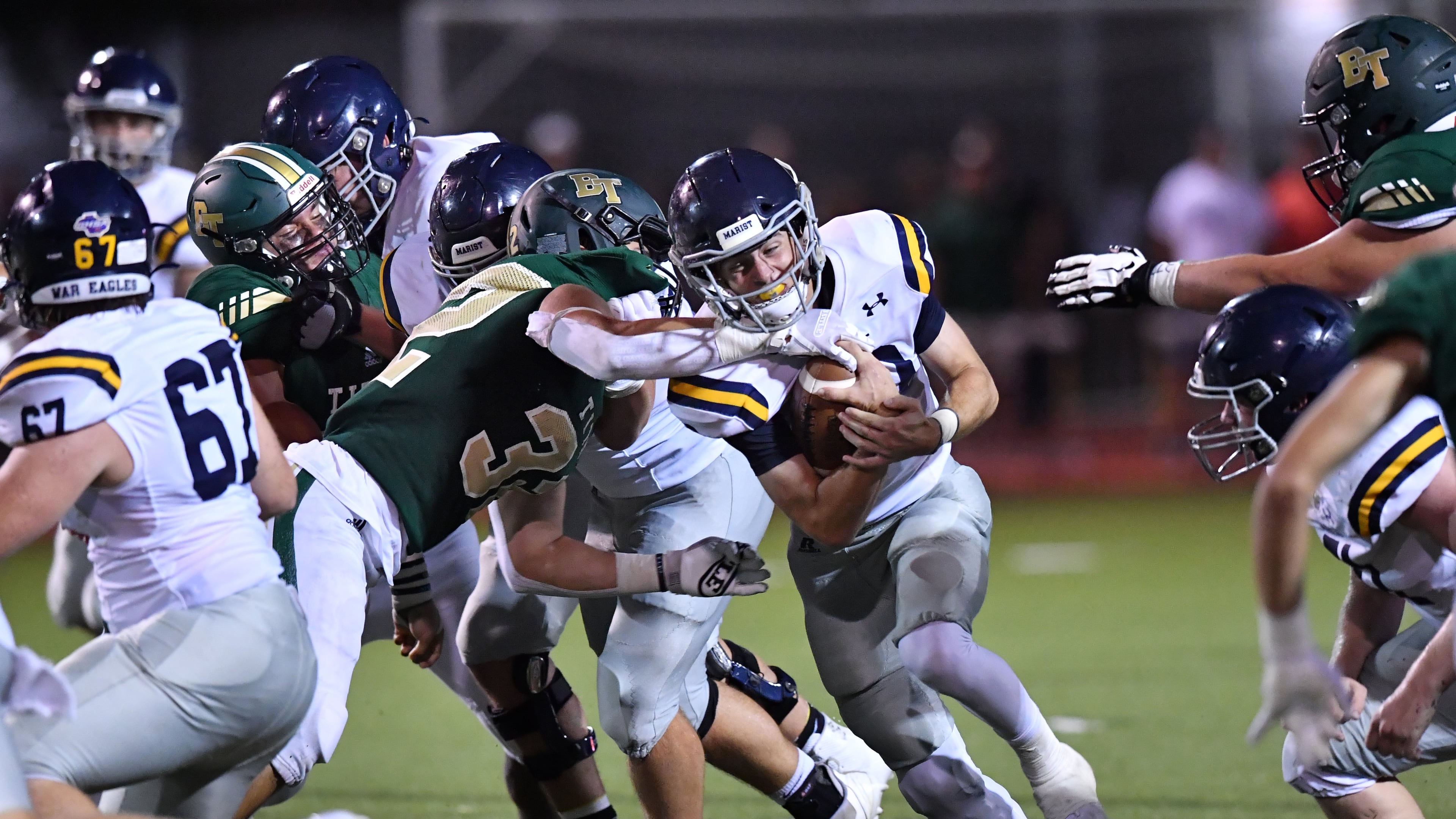 Marist's Champ Davis gets tackled by Blessed Trinity's Mavrick Torrico in the second half at Blessed Trinity Catholic High School in Roswell on Friday, Aug. 27, 2021. (Hyosub Shin/AJC)