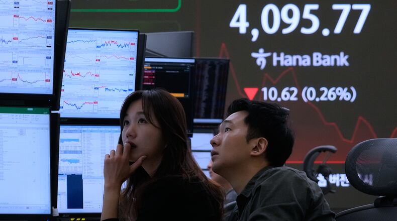 Currency traders watch monitors near a screen showing the Korea Composite Stock Price Index (KOSPI) at the foreign exchange dealing room of the Hana Bank headquarters in Seoul, South Korea, Wednesday, Nov. 12, 2025. (AP Photo/Ahn Young-joon)