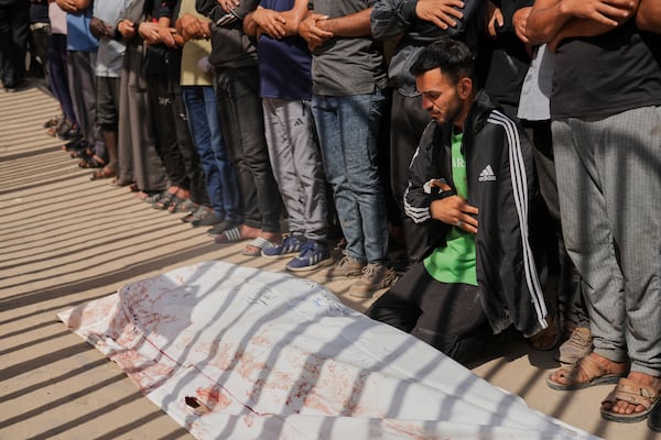 Mourners pray beside the body of Adnan Abu Harb who was killed while heading to a Gaza aid hub, during his funeral at the Nasser Hospital in Khan Younis, southern Gaza Strip, Tuesday, June 3, 2025. (AP Photo/Abdel Kareem Hana)