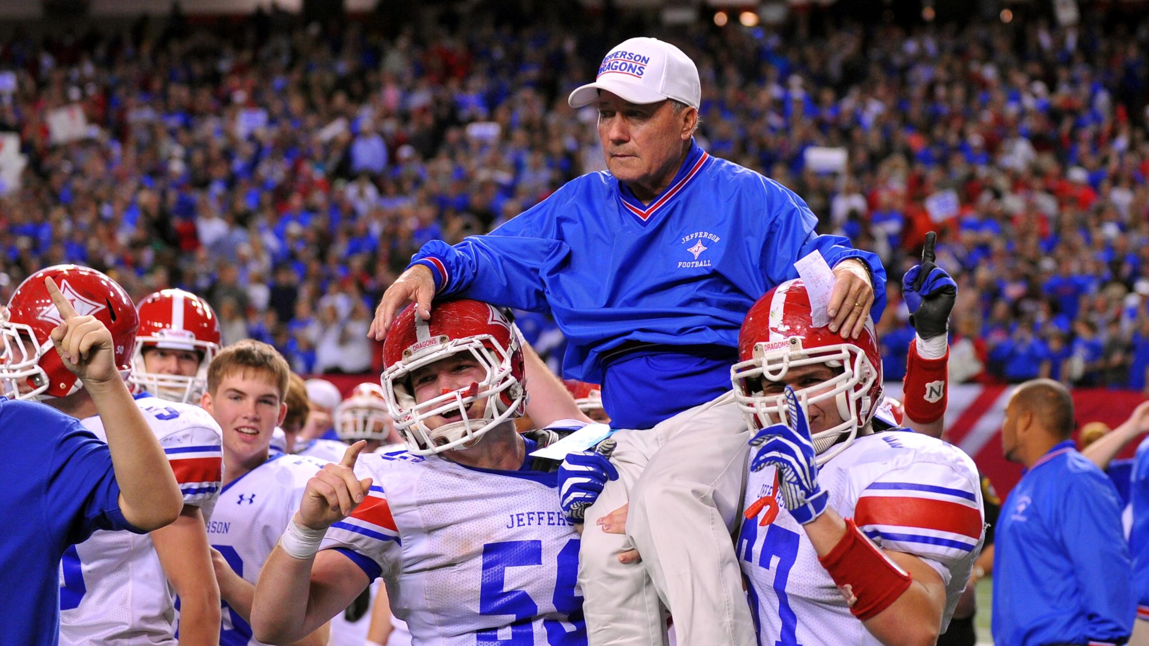 Jefferson head coach T. McFerrin is carried onto the field by Jordan Tyler (left) and Conner Nations. (Brant Sanderlin/AJC)