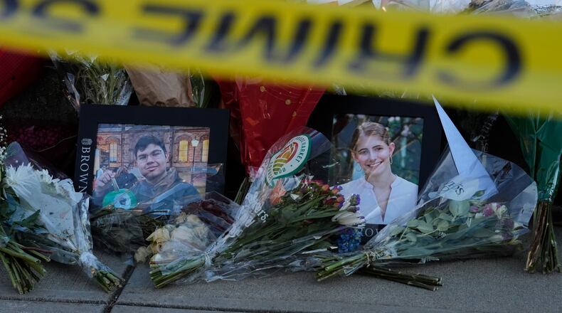 Photos of Brown University shooting victims Mukhammad Aziz Umurzokov, left, and Ella Cook, are seen amongst flowers at a makeshift memorial outside the Engineering Research Center, Tuesday, Dec. 16, 2025, in Providence, R.I.(AP Photo/Robert F. Bukaty)
