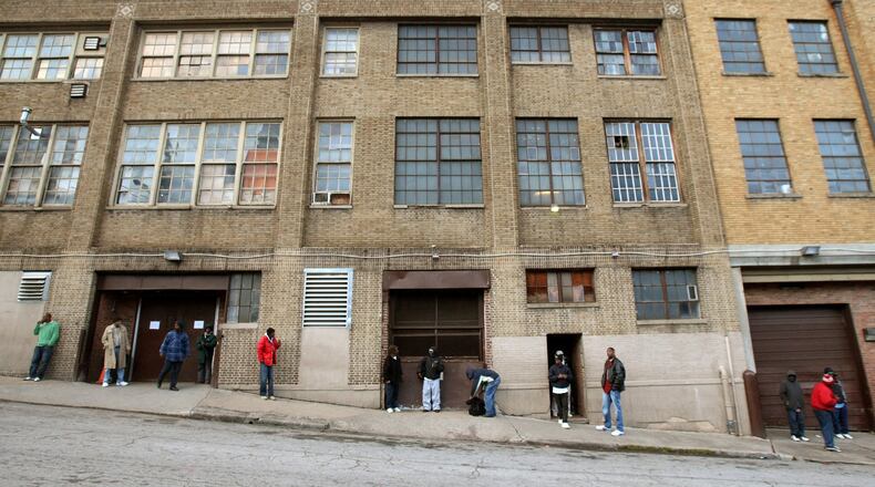 People hang around the entrance to the homeless shelter on Pine Street near the intersection with Peachtree Street in Atlanta. (Jason Getz / AJC file photo / December 2011)