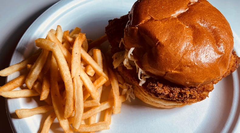 Stats Brewpub's Dirty Bird crispy chicken sandwich comes with vinegar slaw and spicy mayonnaise, and is served here with a side of fries. Bob Townsend for The AJC