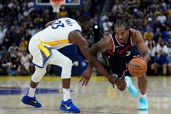 Los Angeles Clippers forward Kawhi Leonard (2) moves the ball while defended by Golden State Warriors forward Draymond Green (23) during overtime of an NBA basketball game Sunday, April 13, 2025, in San Francisco. (AP Photo/Godofredo A. Vásquez)