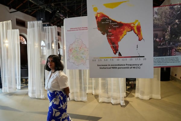 A woman walks past interpretive panels highlighting the impact of heat at the Sweat and Concrete 2025 event in Bengaluru, India, Thursday, May 29, 2025. (AP Photo/Aijaz Rahi)