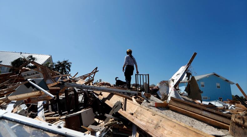 Lynn Ballard, and search dog Toby, of the Boone County, Mo. Urban Search and Rescue team, search rubble in the aftermath of Hurricane Michael in Mexico Beach, Fla., Wednesday, Oct. 17, 2018. Animal recue groups like the Humane Society of the United States are also helping people and pets in the devastated Panhandle.
