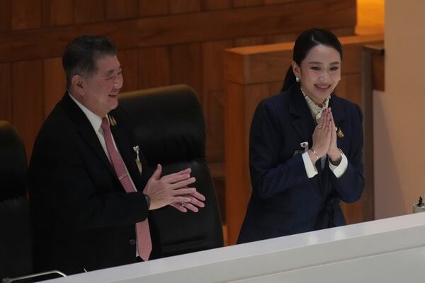 Thailand's Deputy Prime Minister Phumtham Wechayachai, left, and Prime Minister Paetongtarn Shinawatra react after a no-confidence vote against her was defeated in Bangkok, Thailand, Wednesday, March 26, 2025. (AP Photo/Sakchai Lalit)