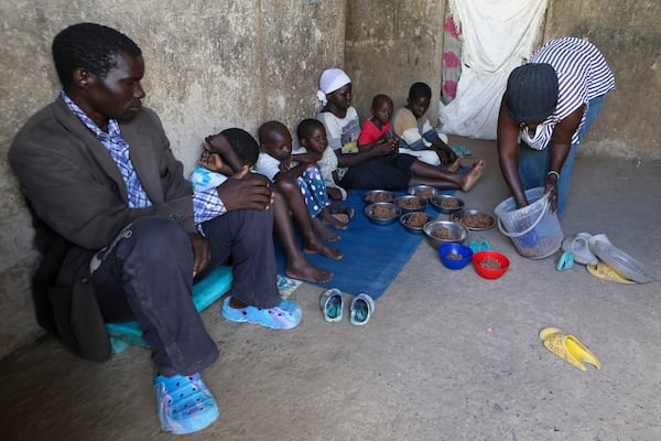 Aujene Cimanimpaye, from the Democratic Republic of Congo, gives food to her family at the Kakuma Refugee Camp in Turkana County, Kenya, Wednesday, June 4, 2025. (AP Photo/Andrew Kasuku)