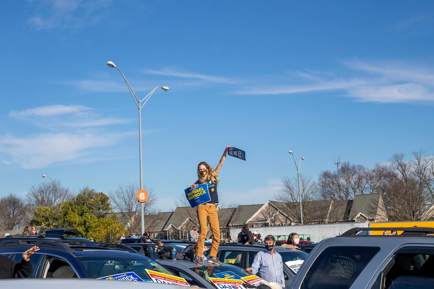 01/04/2021 — Atlanta, Georgia — Chelsea Ashworth, 27, dances on top of her vehicle during a Georgia Democrat U.S. Senate campaign rally in Atlanta’s Peoplestown neighborhood, Monday, January 4, 2021. (Alyssa Pointer / Alyssa.Pointer@ajc.com)