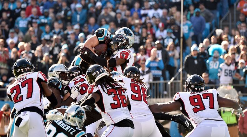CHARLOTTE, NORTH CAROLINA - DECEMBER 23: Christian McCaffrey #22 of the Carolina Panthers jumps for the goal line against Deion Jones #45 of the Atlanta Falcons in the first quarter during their game at Bank of America Stadium on December 23, 2018 in Charlotte, North Carolina. (Photo by Grant Halverson/Getty Images)