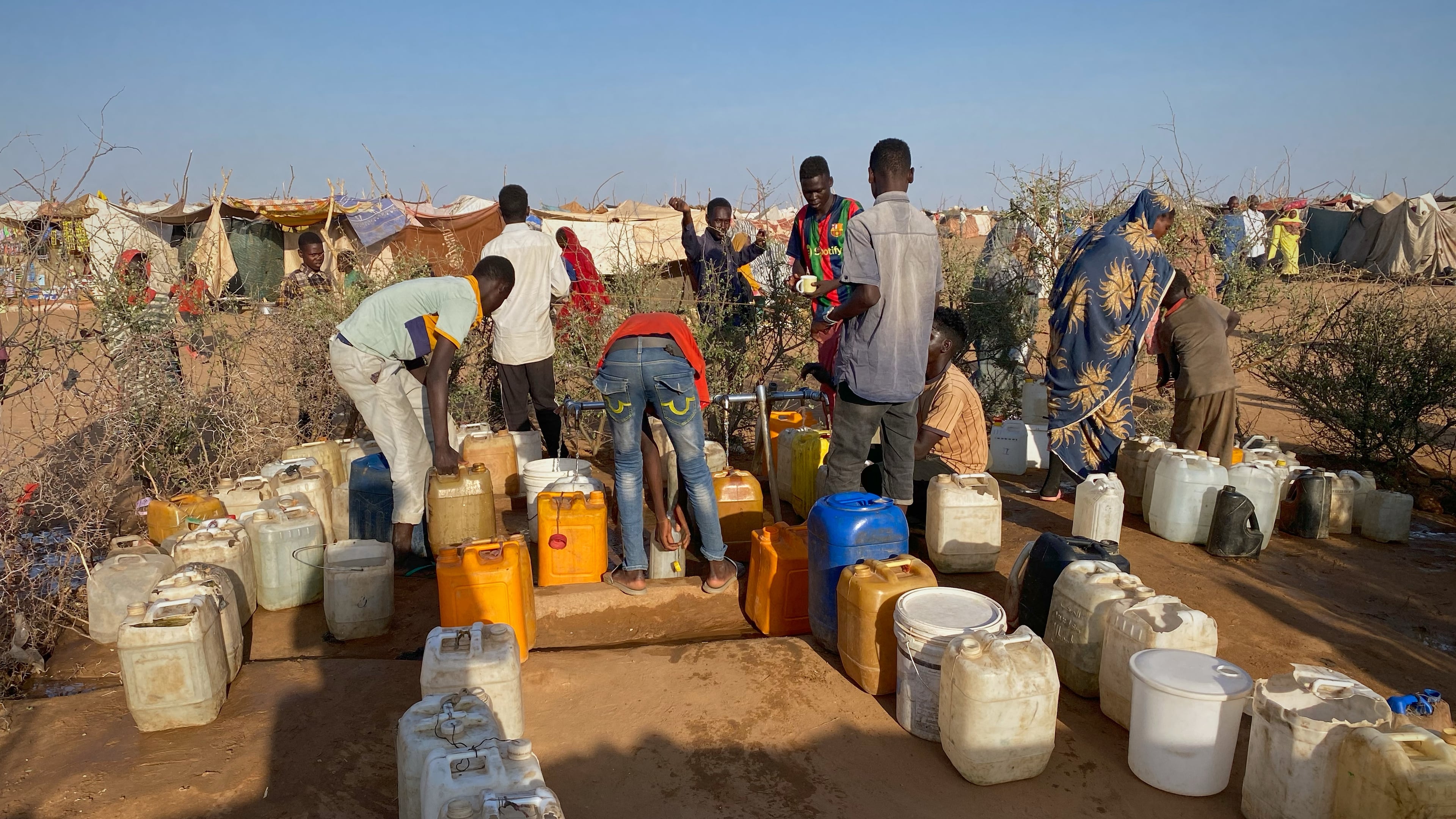 Sudanese men who fled el-Fasher city, after Sudan's paramilitary forces killed hundreds of people in the western Darfur region, collect water at a camp in Tawila, Sudan, Saturday, Nov. 1, 2025. (AP Photo/Mohammed Bakry)