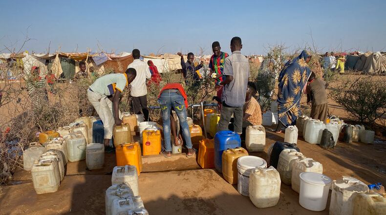 Sudanese men who fled el-Fasher city, after Sudan's paramilitary forces killed hundreds of people in the western Darfur region, collect water at a camp in Tawila, Sudan, Saturday, Nov. 1, 2025. (AP Photo/Mohammed Bakry)