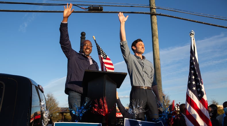 Georgia's new U.S. senators, Raphael Warnock, left, and Jon Ossoff, wave to supporters during a rally in November in Marietta. (Jessica McGowan/Getty Images/TNS)