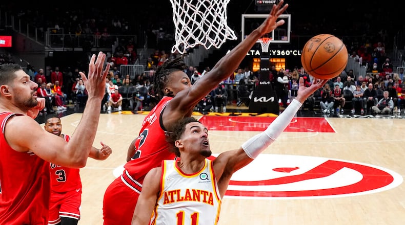 Atlanta Hawks guard Trae Young (11) puts up a shot against the Chicago Bulls' Ayo Dosunmu (12) Thursday, March 3, 2022, in Atlanta. (AP Photo/John Bazemore)