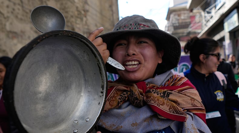 A teacher holds an empty pot during an anti-government protest in La Paz, Bolivia, Tuesday, Sept. 15, 2026. (AP Photo/Juan Karita)