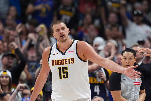 Denver Nuggets center Nikola Jokic is congratulated after making a basket and drawing a foul against the Memphis Grizzlies in the second half of an NBA basketball game Friday, April 11, 2025, in Denver. (AP Photo/David Zalubowski)