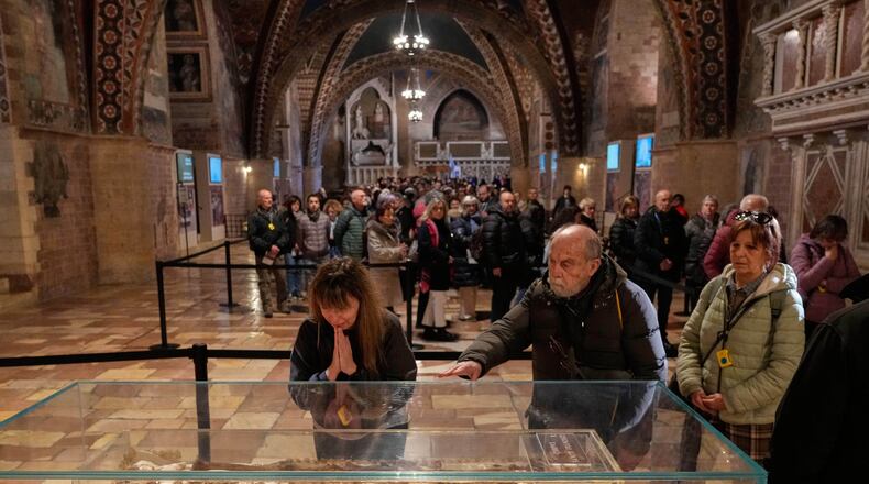 Pilgrims honor the bones of St. Francis during the first public display inside the St. Francis Basilica, marking the 800th anniversary of the saint death, in Assisi, Italy, Sunday, Feb. 22, 2026.(AP Photo/Gregorio Borgia)