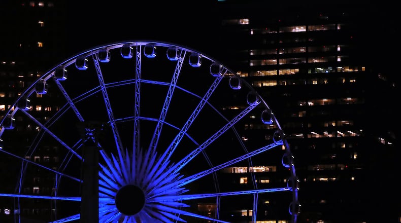 April 9, 2020 Atlanta: A building on the skyline bears the message thanks frontline workers behind the Skyview Ferris Wheel bathed in blue as part of an initiative to salute essential workers on the frontlines of the coronavirus pandemic on Thursday, April 9, 2020, in Atlanta. The Light It Blue event includes more than 150 major sports and entertainment venues and historic landmarks and buildings across the United States.  Curtis Compton ccompton@ajc.com