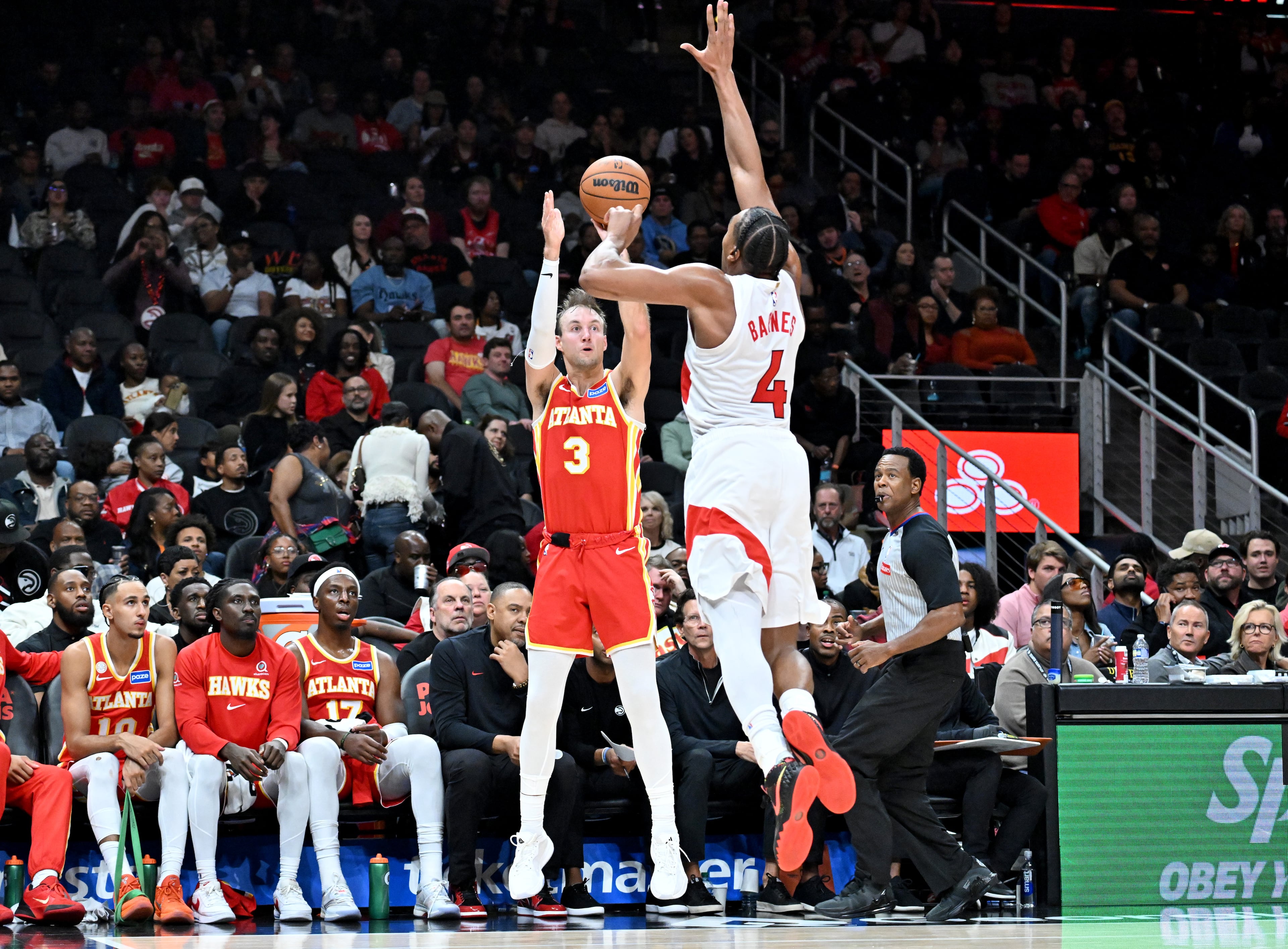 Atlanta Hawks guard Luke Kennard (3) gets off a shot against Toronto Raptors forward/guard Scottie Barnes (4) during the second half in the home opener at State Farm Arena, Thursday, October 22, 2025, in Atlanta. Toronto Raptors won 138-118 over Atlanta Hawks. (Hyosub Shin / AJC)