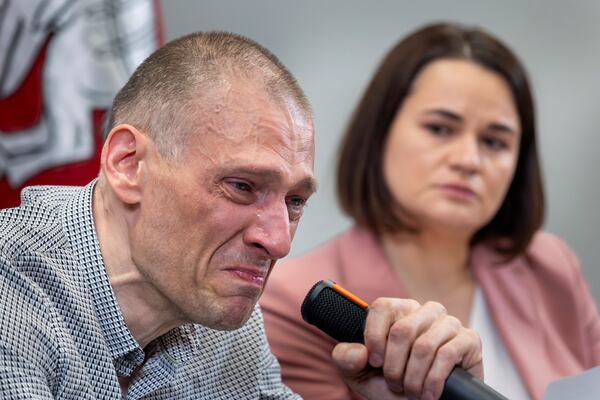Syarhei Tsikhanouski, left, a Belarusian opposition activist released from a Belarusian prison, cries as his wife Belarusian opposition leader Sviatlana Tsikhanouskaya attends a news conference in Vilnius, Lithuania, Sunday, June 22, 2025. (AP Photo/Mindaugas Kulbis)