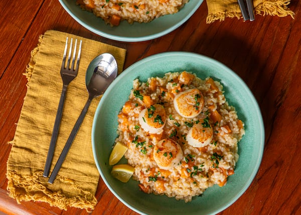 Cooking risotto in the oven frees up your hands to sear the scallops for this approachable, elegant recipe. (Aaliyah Man for the AJC/food styling by Kate Williams)