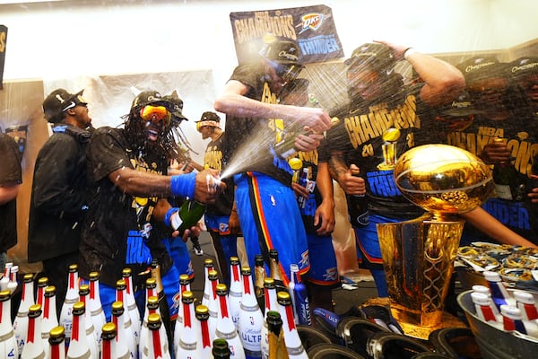 Oklahoma City Thunder guard Luguentz Dort, left, celebrates with teammates in the locker room after winning the NBA basketball championship with a Game 7 victory against the Indiana Pacers Sunday, June 22, 2025, in Oklahoma City. (AP Photo/Julio Cortez)