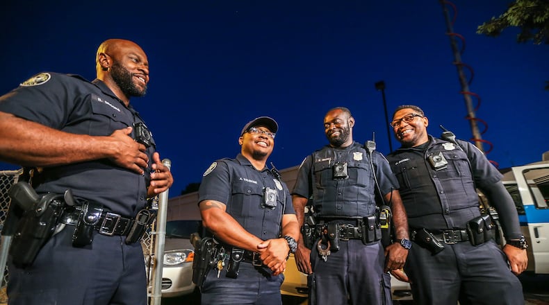 (From left to right) Atlanta police Officers Bill Brooks, Andre Valentine, Elijah McCall and Derek Daniel  helped rescue two people from a fiery crash Wednesday. JOHN SPINK / JSPINK@AJC.COM