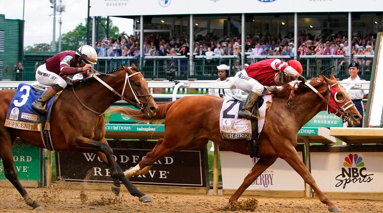 Rich Strike (21), with Sonny Leon aboard, beats Epicenter (3), with Joel Rosario aboard, at the finish line to win the 148th running of the Kentucky Derby horse race at Churchill Downs Saturday, May 7, 2022, in Louisville, Ky. (AP Photo/Mark Humphrey)