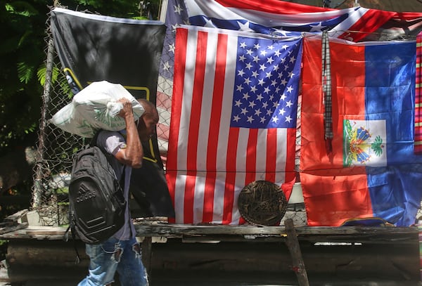 A man walks past a vendor's stall selling U.S. and Haitian flags in Port-au-Prince, Haiti, Thursday, June 5, 2025. (AP Photo/Odelyn Joseph)