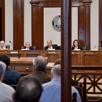 Georgia State Election Board members, from left, Sara Tindall Ghazal, Salleigh Grubbs, Executive Director James Mills, Chair John Fervier, Vice Chair Janice Johnston and Janelle King discuss agendas during the State Election Board’s monthly meeting at the Historic Barrow County Courthouse, Wednesday, Jan. 21, 2026, in Winder. (Hyosub Shin/AJC)