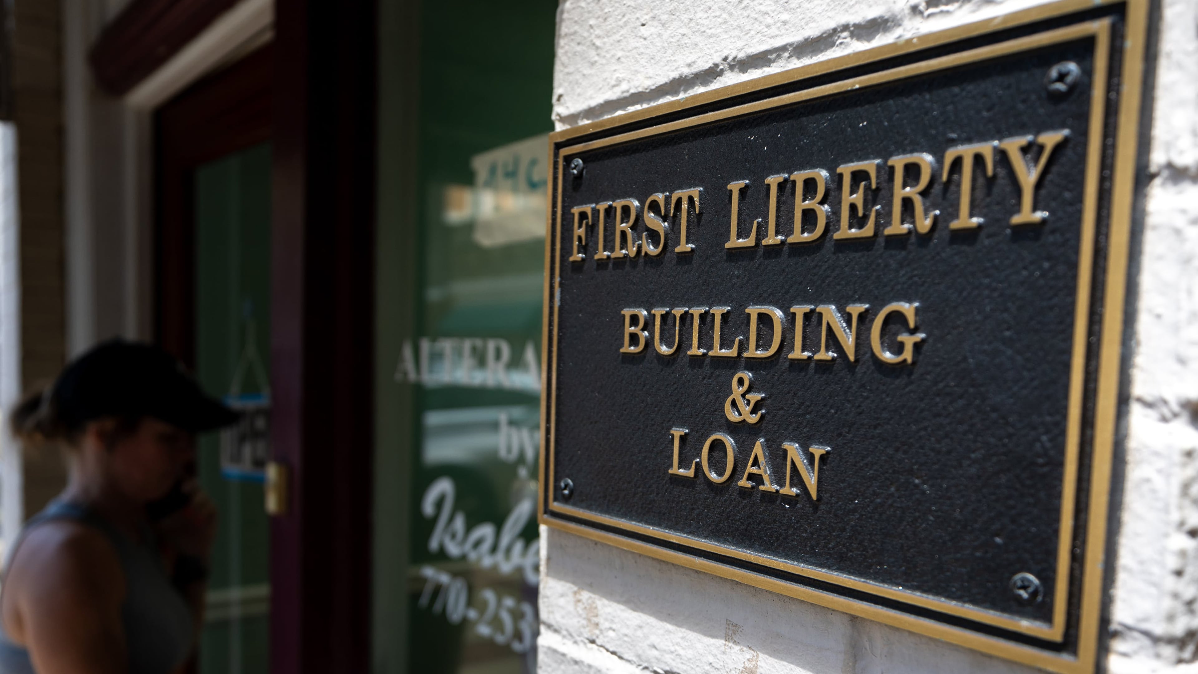 A person walks into the store next to First Liberty Building & Loan in downtown Newnan on Wednesday, July 2, 2025. Brant Frost IV shut down First Liberty on June 27, less than two weeks before the U.S. Securities and Exchange Commission filed suit against him and his company. Since then, a federal judge has frozen the company's assets. (Arvin Temkar/The Atlanta Journal-Constitution/TNS)
