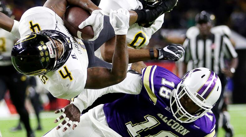Grambling State’s Martez Carter (4) leaps over Alcorn State’s Leishaun Ealey and scores the winning touchdown in the Southwestern Athletic Conference Championship game Saturday, Dec. 3, 2016, in Houston. (Yi-Chin Lee/Houston Chronicle via AP)