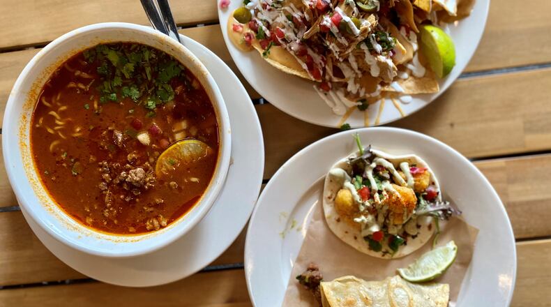 A feast from Pretty Little Tacos: (clockwise starting from the left) spicy birria ramen with steak, chicken nachos and a Creole cauliflower and steak taco. (Wendell Brock for The Atlanta Journal-Constitution)