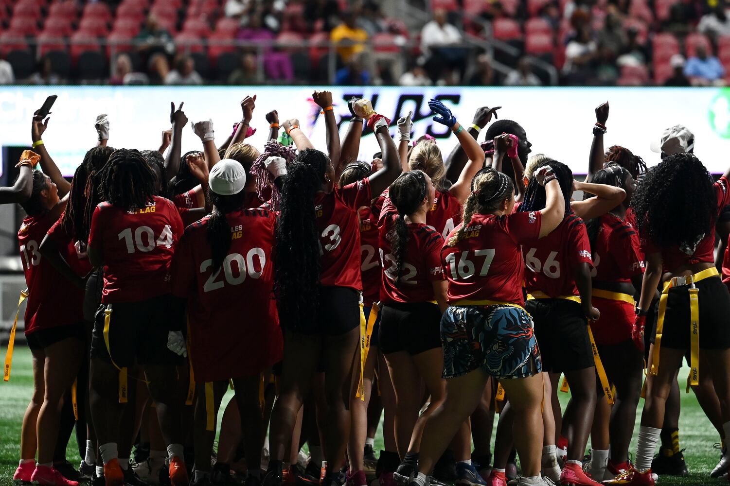 Athletes cheer at the end of a training drill during 5th annual Girls Flag Football Showcase. (Daniel Varnado for the AJC)