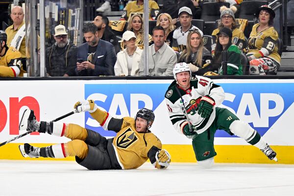 Vegas Golden Knights defenseman Brayden McNabb (3) and Minnesota Wild center Gustav Nyquist (41) fall to the ice during the third period of Game 2 of a first-round NHL hockey playoff series Tuesday, April 22, 2025, in Las Vegas. (AP Photo/David Becker)