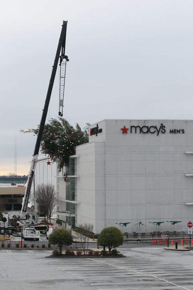 Crane buckles, leaving Christmas tree hanging off roof