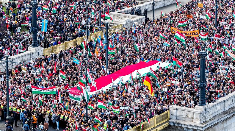 In this photo taken by a drone, participants of the Peace March organized by the pro-government Civil Unity Forum (COF) and its foundation Civil Unity Public Benefit Foundation (COKA) gather at the Buda side of Margaret Bridge in Budapest, Hungary, Thursday, Oct. 23, 2025, on the 69th anniversary of the Hungarian revolution and war of independence against communist rule and the Soviet Union in 1956. (Zsolt Czegledi/MTI via AP)