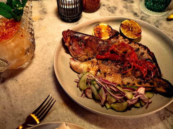 The whole grilled snapper at Fishbar comes with escovitch sauce and a carrot-citrus mojo that draws on traditional Caribbean flavors. (Courtesy of Randall Patrick/Southern Cross Hospitality)
