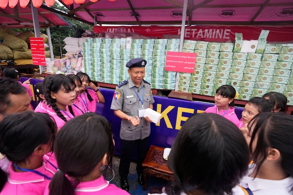 A police officer explains illegal narcotics to students during a destruction ceremony to mark International Day against Drug Abuse and Illicit Trafficking, on the outskirts of Yangon, Myanmar, Thursday, June 26, 2025. (AP Photo/Thein Zaw)