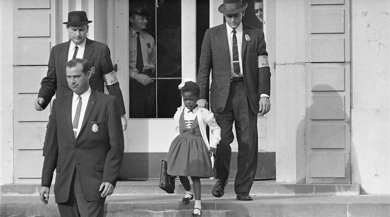 U.S. Deputy Marshals escort 6-year-old Ruby Bridges from William Frantz Elementary School in New Orleans, in this November 1960. In 2014 a statue in her likeness was unveiled on the campus. (AP Photo/File)