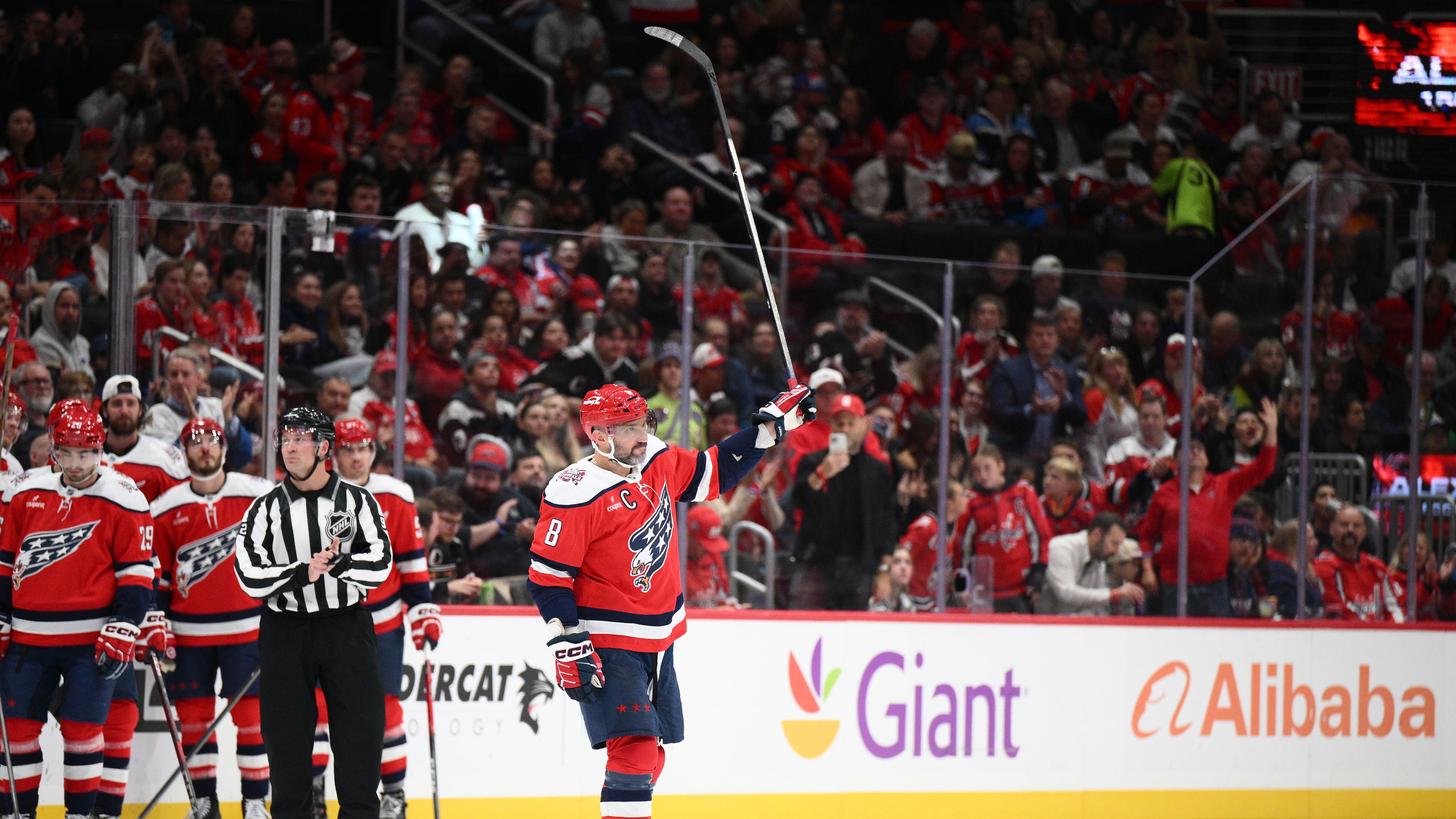 Washington Capitals left wing Alex Ovechkin (8) raises his stick to the crowd after he was recognized for playing in his 1,500th NHL hockey game during a break in the action in the first period against the Ottawa Senators, Saturday, Oct. 25, 2025, in Washington. (AP Photo/Nick Wass)