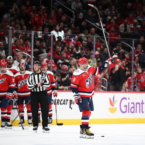 Washington Capitals left wing Alex Ovechkin (8) raises his stick to the crowd after he was recognized for playing in his 1,500th NHL hockey game during a break in the action in the first period against the Ottawa Senators, Saturday, Oct. 25, 2025, in Washington. (AP Photo/Nick Wass)