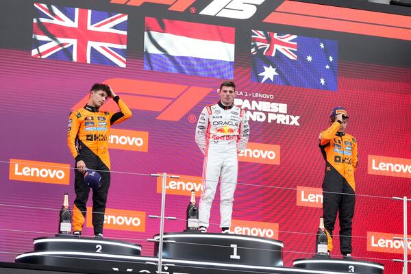 Red Bull driver Max Verstappen of the Netherlands, center, Second placed McLaren driver Lando Norris of Britain, left, and third place McLaren driver Oscar Piastri of Australia, right, stand on the podium after the Japanese Formula One Grand Prix at the Suzuka Circuit in Suzuka, central Japan, Sunday, April 6, 2025. (AP Photo/Hiro Komae)
