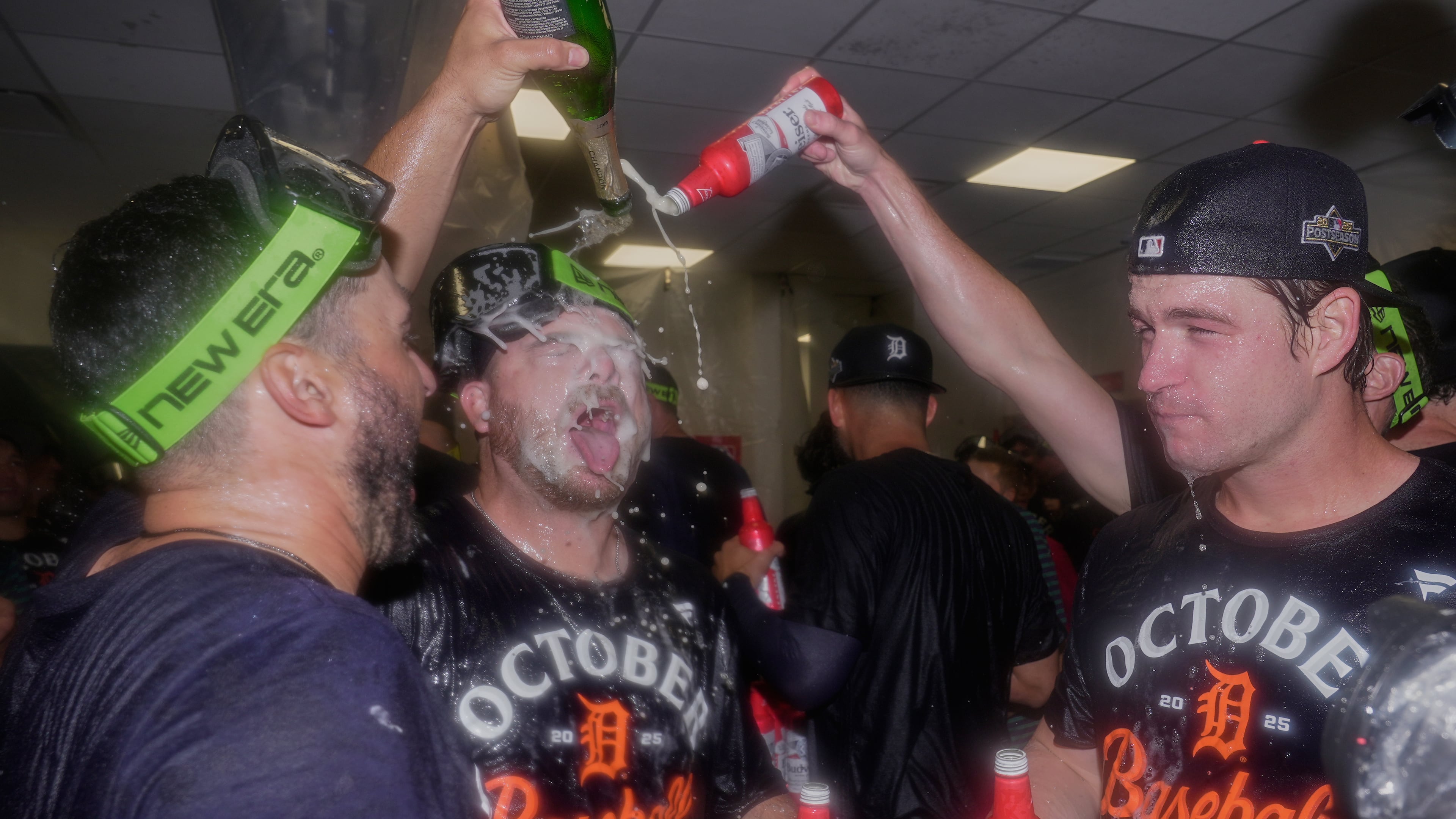 Detroit Tigers bullpen catcher Chris Chinea, left, catcher Jake Rogers, center, and catcher Dillon Dingler, right, celebrate in the locker room after defeating the Cleveland Guardians in Game 3 of an American League Wild Card baseball playoff series in Cleveland, Thursday, Oct. 2, 2025. (AP Photo/Sue Ogrocki)