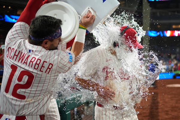 Philadelphia Phillies' Otto Kemp, right, is dunked by Kyle Schwarber after the Phillies won a baseball game against the Chicago Cubs Monday, June 9, 2025, in Philadelphia. (AP Photo/Matt Slocum)