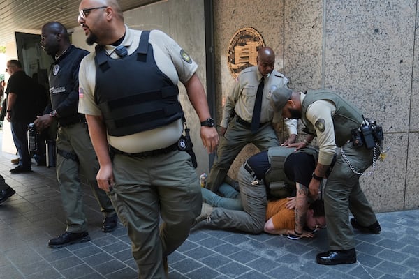 Law enforcement detain a protester at the U.S. Department of Justice Federal Bureau of Prisons after federal immigration authorities conducted an operation on Friday, June 6, 2025, in Los Angeles. (AP Photo/Jae C. Hong)