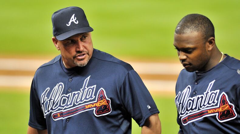 Sep 10, 2013; Miami, FL, USA; Atlanta Braves manager Fredi Gonzalez (left) talks with left fielder Justin Upton (right) as they head back to the dugout after Upton fouled a pitch off his leg during the fourth inning against the Miami Marlins at Marlins Park. Mandatory Credit: Steve Mitchell-USA TODAY Sports