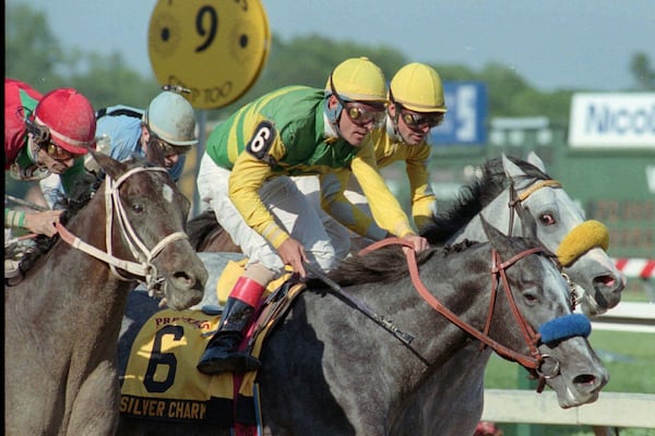 FILE - Jockey Gary Stevens is up in the stirrups of Silver Charm just past the finish line after beating out Captain Bodgit, left, with Alex Solis up, and Free House, right rear, with Paco Gonzalez up, to win the 122nd running of the Preakness Stakes horse race, Saturday, May 17, 1997, at Pimlico Race Course in Baltimore. (AP Photo/Steve Nesius File)
