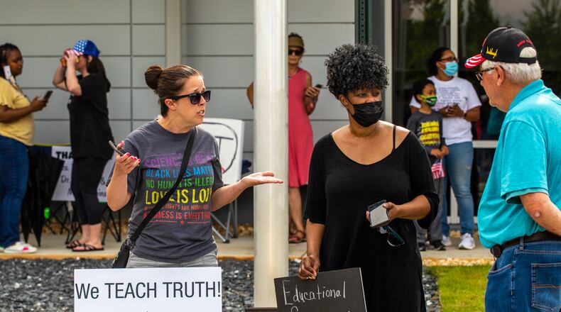 Before a Cobb County of Education board meeting begins, Sandra Davis, a Cobb County media specialist, from left, and Janet Arnold Savage, center, debate with Leroy Emkin, right, a Cobb resident who has three children who went through the Georgia public education system. Teachers, parents and local residents gathered to voice their opinions on critical race theory and what Cobb County teaching and the reviews initiated by the school board on June 10, 2021. (Jenni Girtman for The Atlanta Journal Constitution)